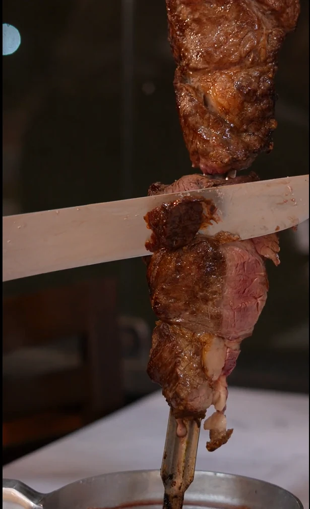 Carne sendo servida no espeto